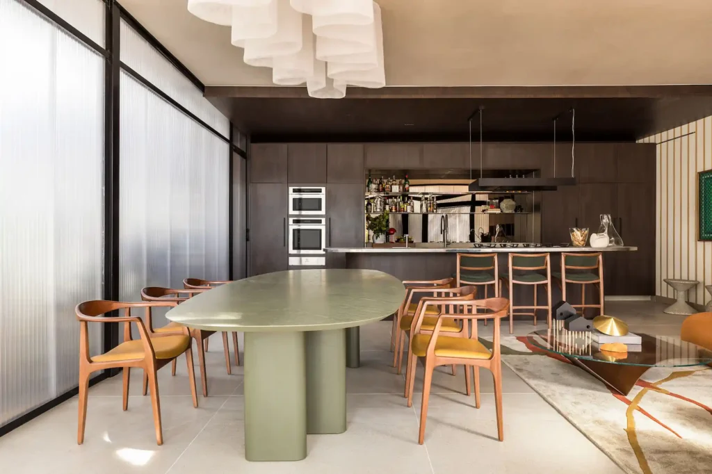Ambiente moderno de cozinha e sala de jantar no evento CASACOR Paraná, com móveis de design contemporâneo, iluminação elegante e detalhes de decoração sofisticados