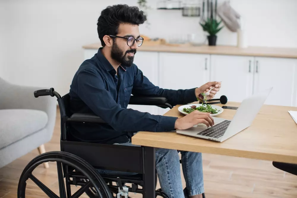 Homem sorridente tomando café em varanda de apartamento durante mudança de endereço, com vista urbana ao fundo. Simboliza tranquilidade e privacidade na nova etapa.