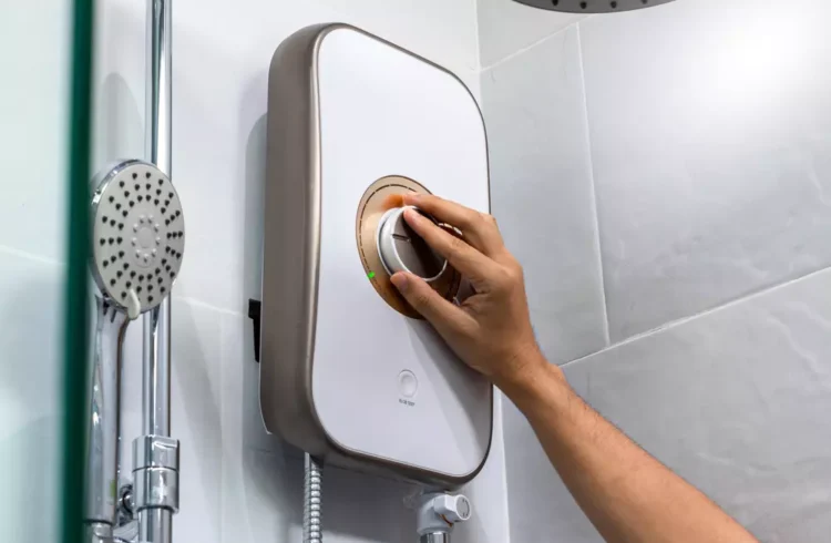 Aparelho de aquecedor de água sendo ajustado na parede do banheiro, próximo ao chuveiro, ideal para aquecer água de forma eficiente.