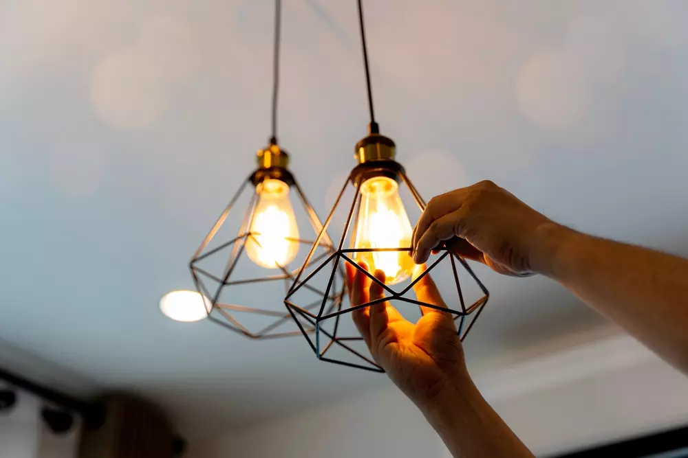 Iluminação externa estratégica no design antipragas, destacando luminárias com lâmpadas decorativas em ambiente interno modernizado.