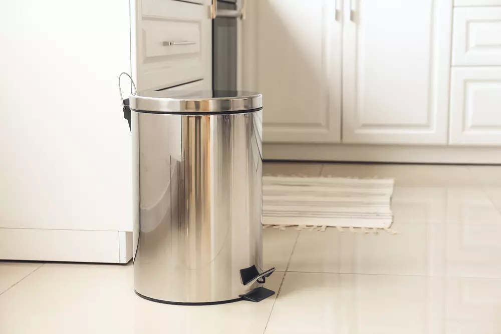 Lixeira de aço inox em ambiente de cozinha bem organizado, promovendo limpeza e organização do espaço.