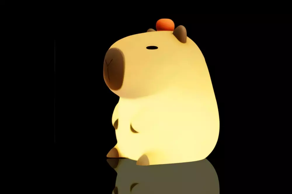 Lanterna em forma de capivara com luz amarela suave, destacando-se em fundo preto, criando um efeito delicado e fofo.