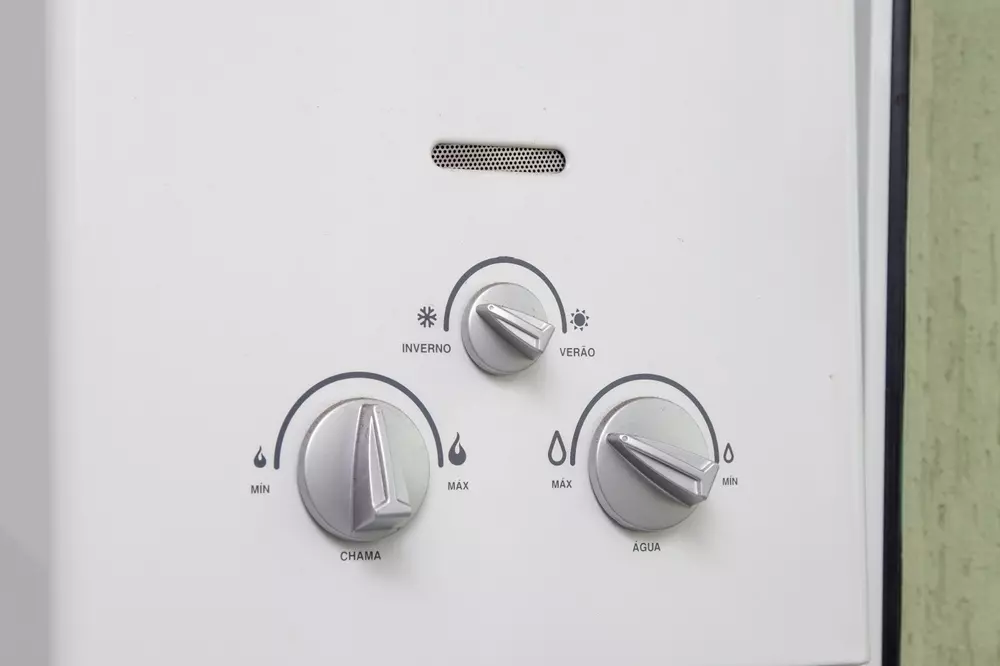 Painel de controle de um aquecedor de água com botões ajustáveis para temperatura, modo inverno e verão, usado para regular o aquecimento de água.