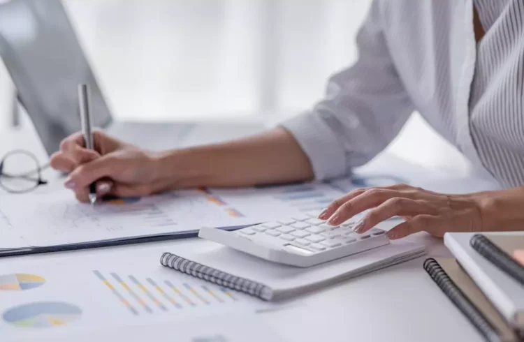 Pessoa analisando documentos financeiros e cálculos relacionados ao valor venal do imóvel, importante para entender seu impacto financeiro.