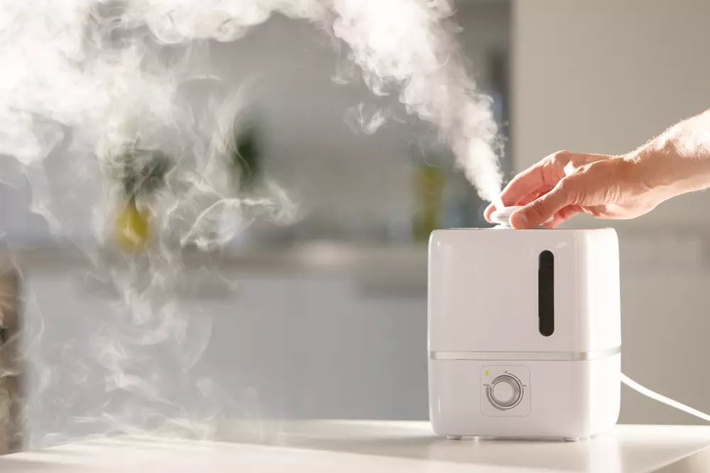 Aromatizador de ar em funcionamento mostrando a névoa de vapor e a luz indicadora, ideal para aromatização e purificação do ar em ambientes internos.