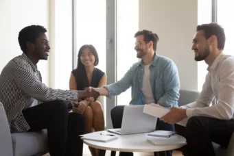 Reunião de intervenientes anuentes em um ambiente de escritório, com pessoas sorridentes e formando um acordo importante, simbolizando consentimento e colaboração.