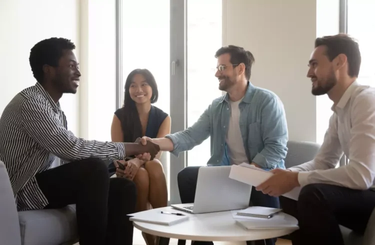 Reunião de intervenientes anuentes em um ambiente de escritório, com pessoas sorridentes e formando um acordo importante, simbolizando consentimento e colaboração.
