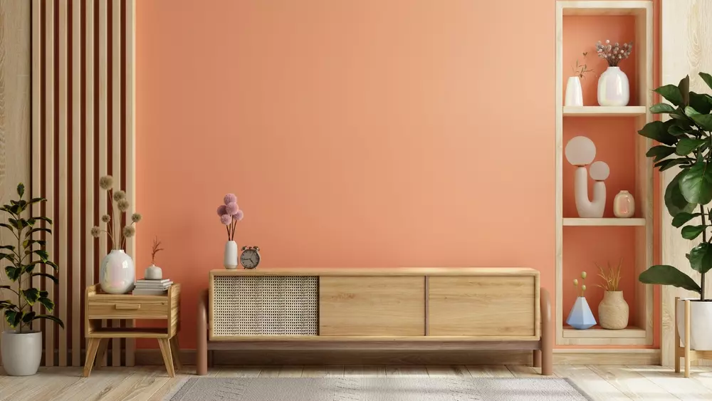 Decoração de living com cores suaves em estilo romântico, incluindo estante com vasos e plantas, ambiente aconchegante e elegante.