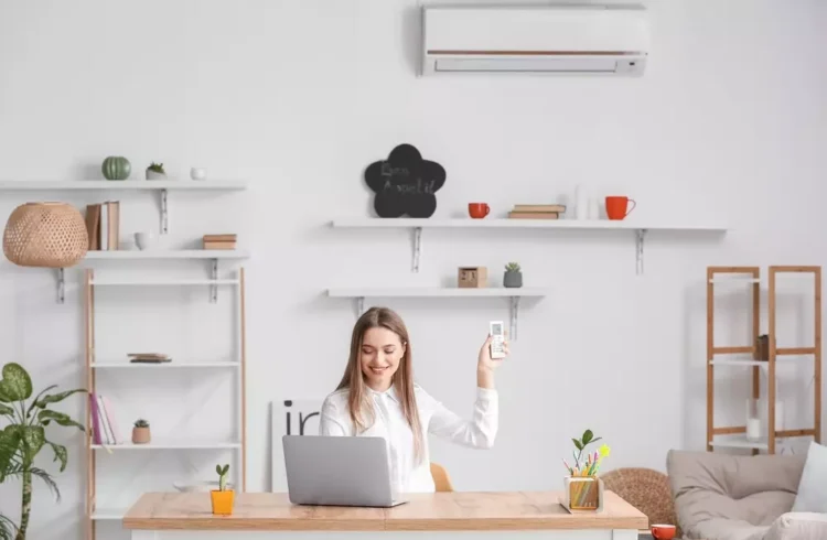 Uma mulher feliz na decoração de uma sala moderna com ar condicionado integrado ao ambiente, mostrando como integrar o ar condicionado na decoração.