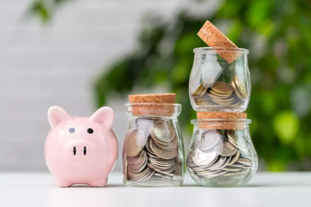 Imagem ilustrativa do método dos potes com três potes de vidro e moedas, destacando a divisão da renda em diferentes 'potes' para organização financeira.