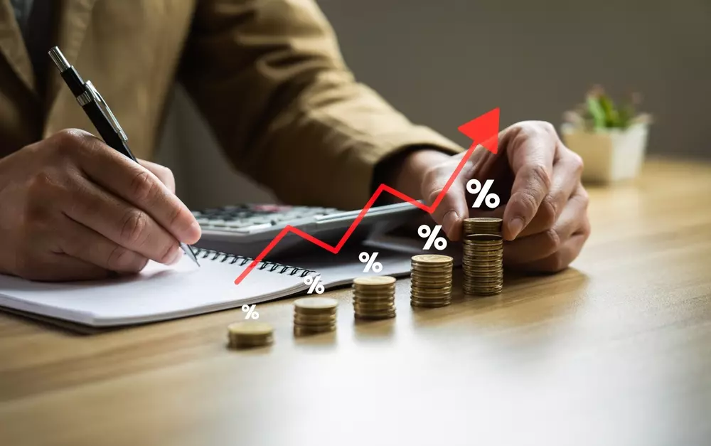Uma pessoa analisando crescimento financeiro, com pilhas de moedas, gráfico de linha ascendente, assinando planejamento financeiro com a regra do 1%