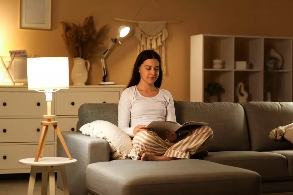 Sala de estar aconchegante com abajur de tamanho médio, iluminação suave e decoração moderna, ideal para leitura e momentos de relaxamento.