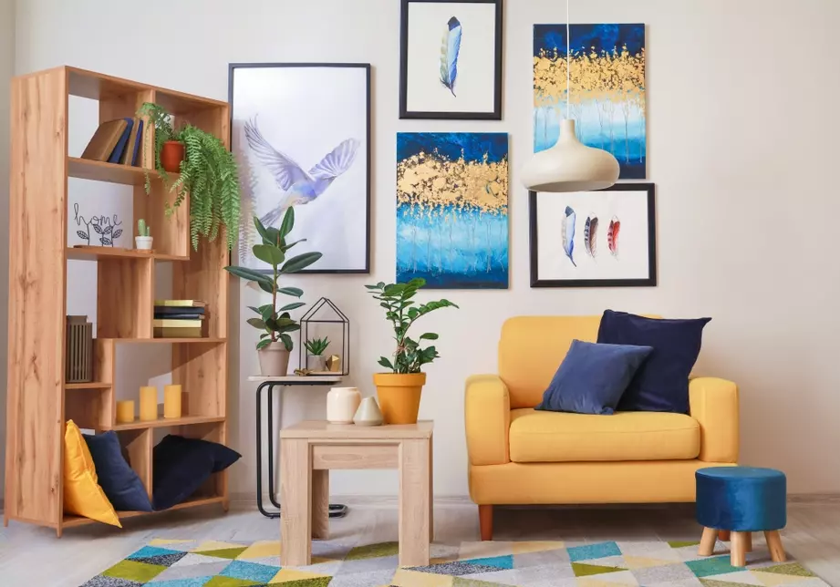 Sala de estar decorada com estilo cluttercore, destacando sobreposições de cores vibrantes, estampas variadas de quadros na parede, móveis coloridos e uma atmosfera aconchegante.