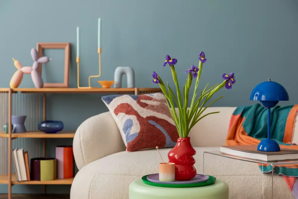 Decoração de primavera com arranjo de flores lilases em vaso vermelho, ambientes com cores suaves, objetos decorativos modernos e almofadas coloridas