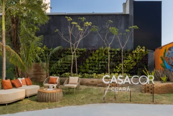 Casacor Ceará 2025, com área externa de convivência, mobiliário confortável, muitas plantas e uma parede com grafite artístico