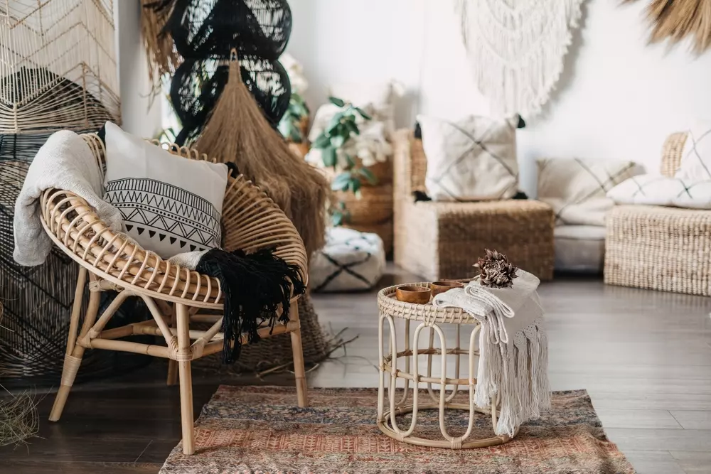 Decoração de interior com estilo moto boho, com cadeiras de vime, almofadas e objetos rústicos em ambiente aconchegante.