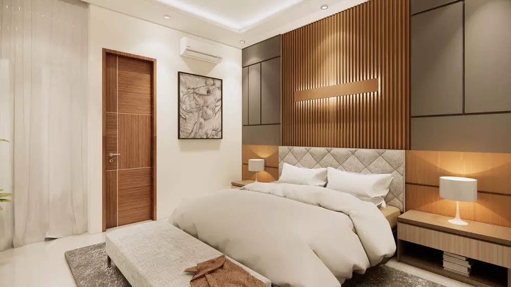 quarto de casal com cabeceira lambri, edredom bege, luminárias de leitura ao lado da cama e paredes claras