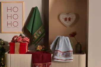 Decoração natalina com toalhas de rosto com tema de Natal, presentes, enfeites e árvore de Natal iluminada que remetem ao cheiro do Natal e ao espírito festivo.