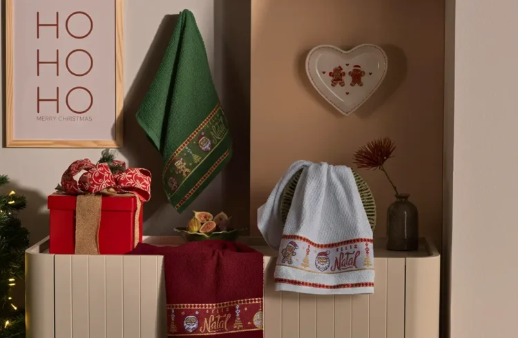 Decoração natalina com toalhas de rosto com tema de Natal, presentes, enfeites e árvore de Natal iluminada que remetem ao cheiro do Natal e ao espírito festivo.