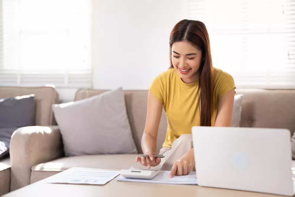 mulher feliz organizando suas contas em casa