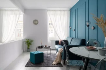 Interior de sala moderna com parede azul profunda que representa a cor do ano 2026, decorada com móveis elegantes, iluminação suave e detalhes decorativos sofisticados.