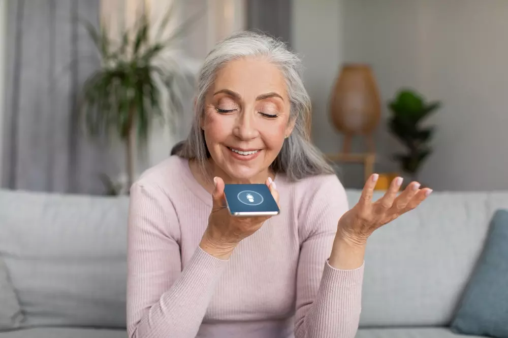 Idosa usando smartphone com tecnologia assistiva para envelhecimento ativo, promovendo integração digital e bem-estar na gerontecnologia.