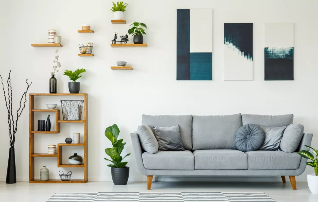 Decorar a parede atrás do sofá com quadros modernos e plantas, criando um ambiente aconchegante e elegante na sala de estar