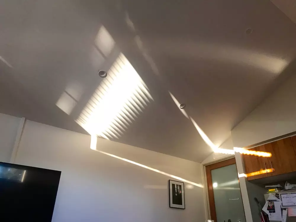 Teto branco com reflexo do vidro canelado criando efeito decorativo