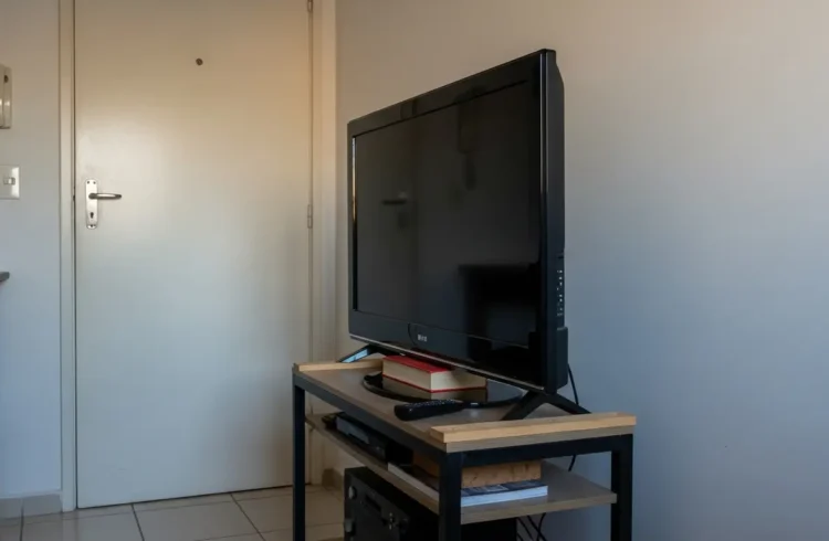 Apoio televisão improvisada usando livros e uma mesa simples