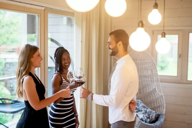 Grupo de amigos em uma varanda pequena Réveillon decorada, com luzes e janta