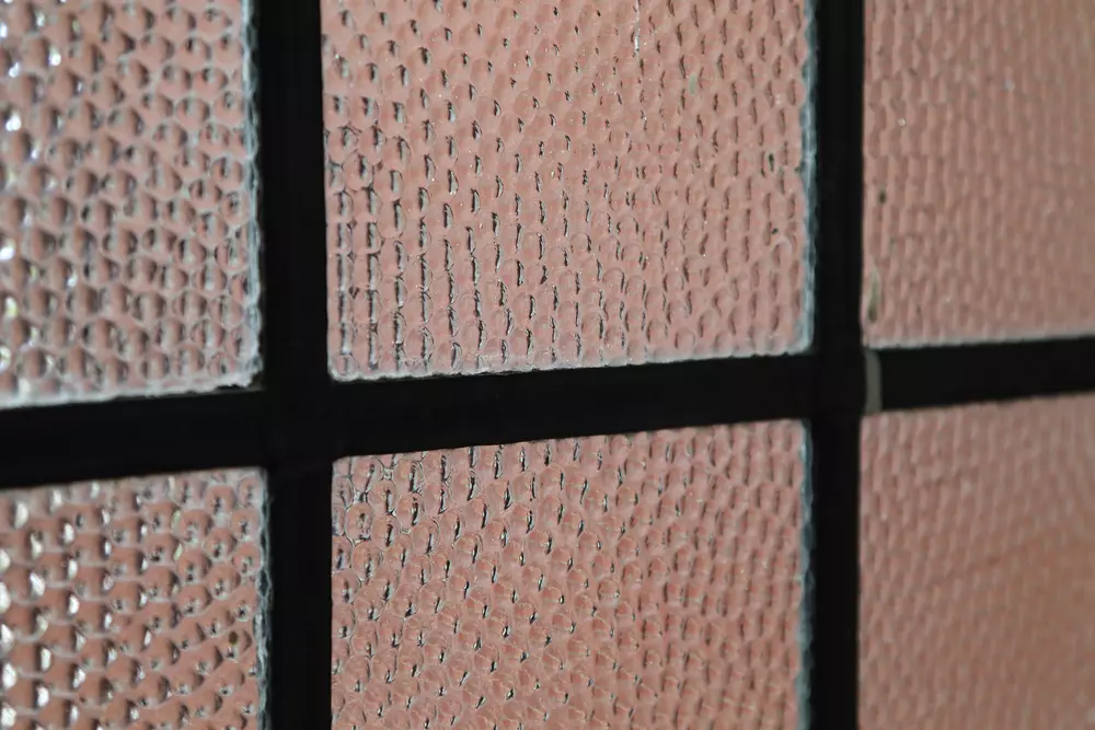 Janela com vidro canelado e moldura de metal preto