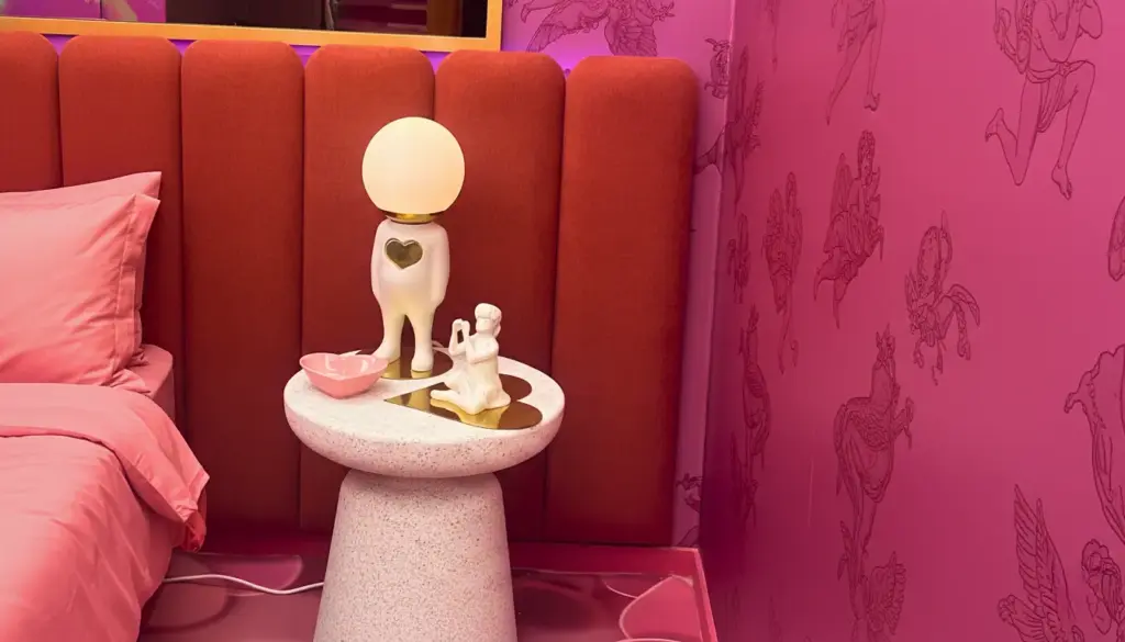 Detalhes do quarto rosa do BBB26 com cabeceira vermelha, parede pink decorada com desenhos de cavalos