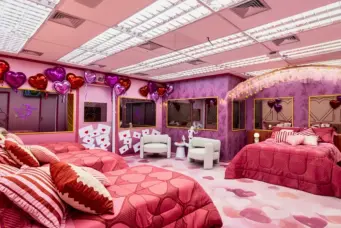 Quarto BBB26 Rosa decorado com balões de coração, cama rosa, televisão e decoração temática romântica
