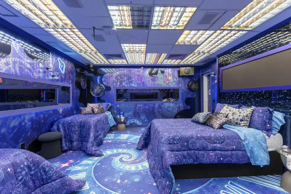 Quarto do BBB 26 Jardim Eternidade, decorado com temas cósmicos e iluminação futurista, ideal para participantes do reality show em um ambiente inspirado no espaço.