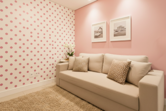 Decoração de sala com parede de poás rosa, sofá confortável e adereços decorativos, criando um ambiente aconchegante e delicado.