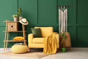 Decoração estilo Brazilcore com parede verde escura, sofá amarelo, almofada verde, acessórios naturais, plantas e itens decorativos rústicos, ideal para um ambiente acolhedor e com forte influência brasileira.