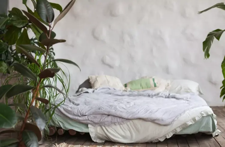 Cama tatame confortável com plantas ao redor, tema de decoração minimalista e aconchegante.