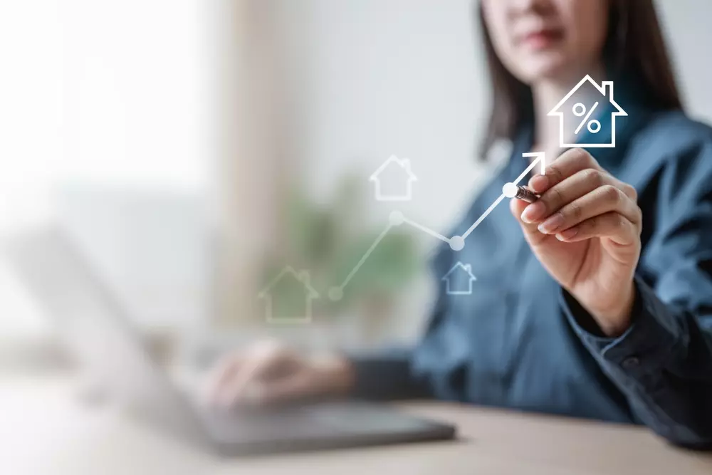 Uma pessoa interagindo com gráficos e ícones relacionados a imóveis, hipotecas e financiamentos, ideal para quem busca informações sobre financiamento imobiliário e taxas de juros