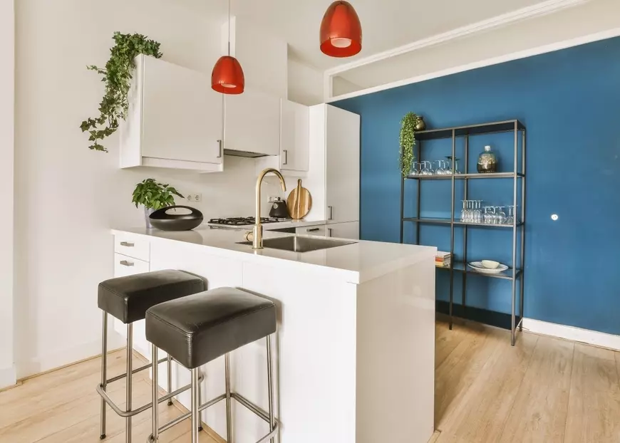 Uma cozinha moderna com parede azul de 2026, destaque para cores de 2026 incluindo azul puro e coral, com detalhes em branco e móveis contemporâneos.