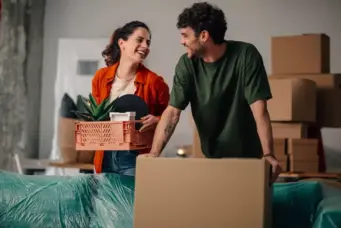 Casal feliz usando cartão de crédito para conquistar o sonho de comprar um apartamento, simbolizando inteligência financeira e planejamento financeiro.