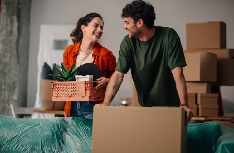 Casal feliz usando cartão de crédito para conquistar o sonho de comprar um apartamento, simbolizando inteligência financeira e planejamento financeiro.