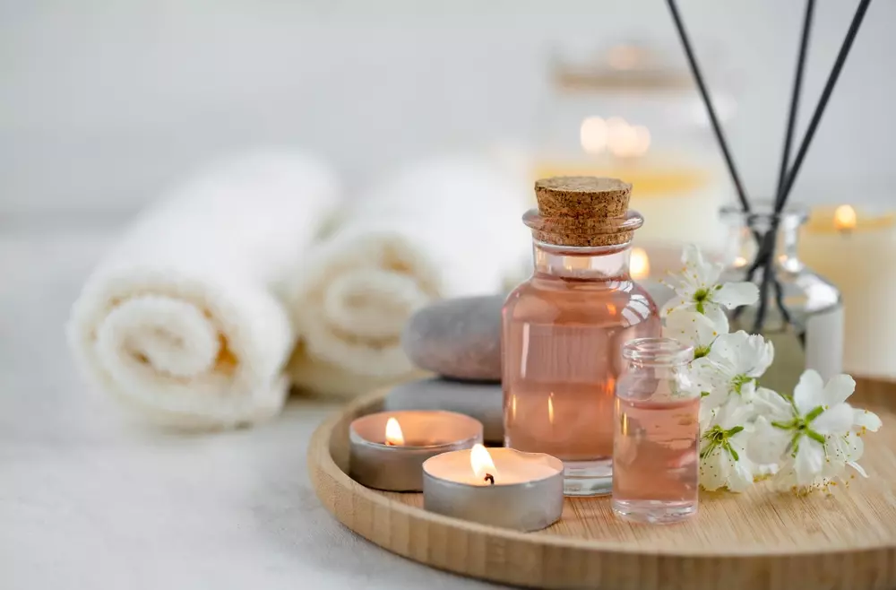 Spa com óleos essenciais e velas aromáticas, ideal para momentos de relaxamento e bem-estar, com toalhas de algodão ao fundo