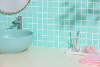 Parede com azulejos em tom de azul claro, mostrando diferentes tipos de rejunte utilizados na instalação, ideal para ambientes de banheiro.