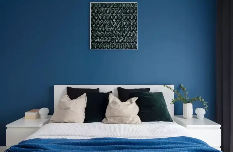 Decoração de quarto moderno com cores de 2026, destaque para parede azul, roupas de cama em tons neutros, com detalhes em verde e branco, criando ambiente sofisticado e aconchegante.