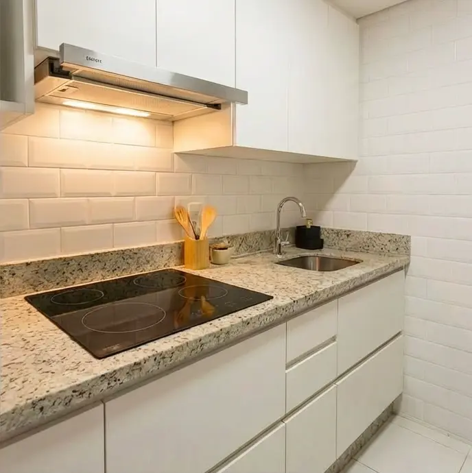 Cozinha pequena e aconchegante com um cooktop embutido na bancada.