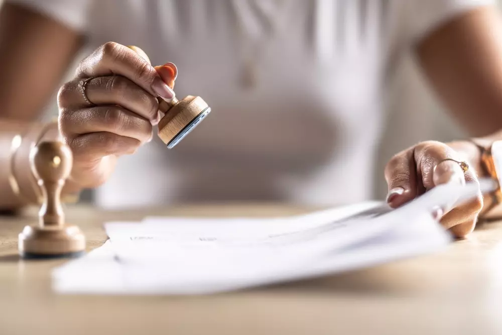 Mulher fazendo prenotação em documentos oficiais com carimbo e selo. Processo de agendamento ou reserva utilizando assinatura e impressão de carimbo.