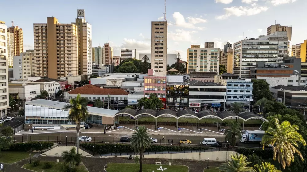 Vista aérea do centro de Londrina mostrando edifícios urbanos, ruas e uma praça pública cercada por estruturas comerciais e residenciais.