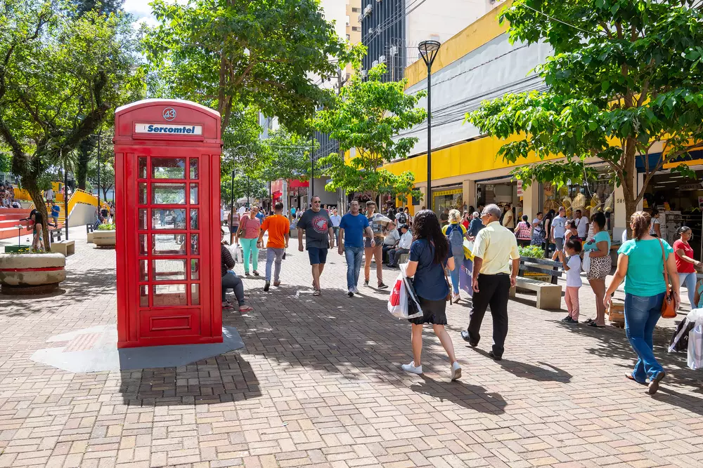 Centro de Londrina. Pessoas fazendo compras e caminhando no calçadão. Cabine telefônica vermelha, telefone público.