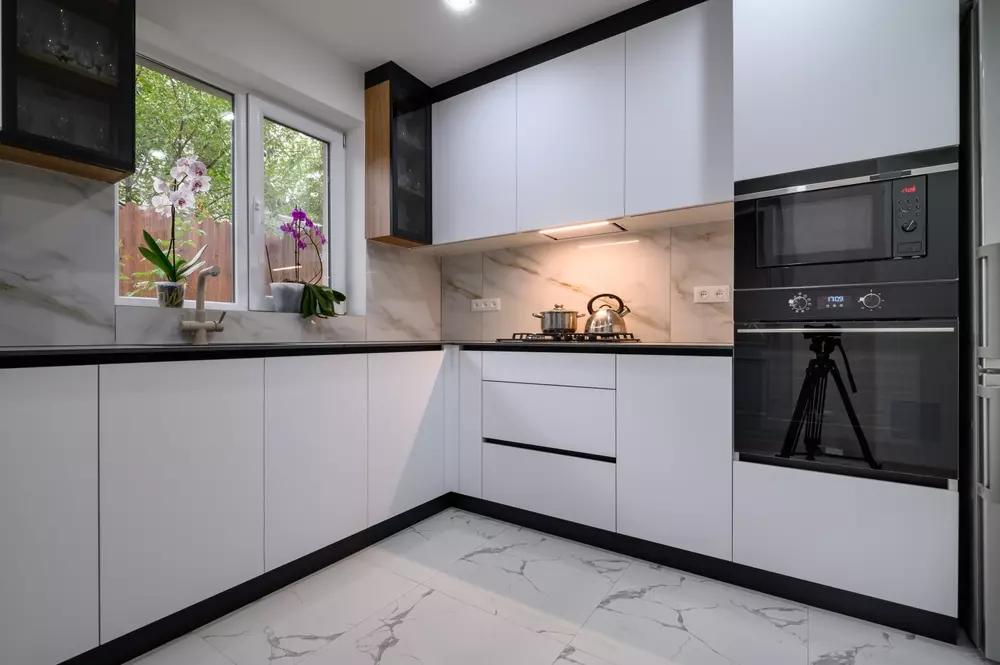 Cozinha moderna com porcelanatos marmorizados, revestimentos elegantes e detalhes em branco e preto, ideal para decoração contemporânea e sofisticação.