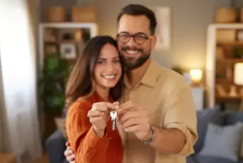 Casal feliz segurando chaves de uma casa, simbolizando conquista da casa própria com o programa Casa Sergipana